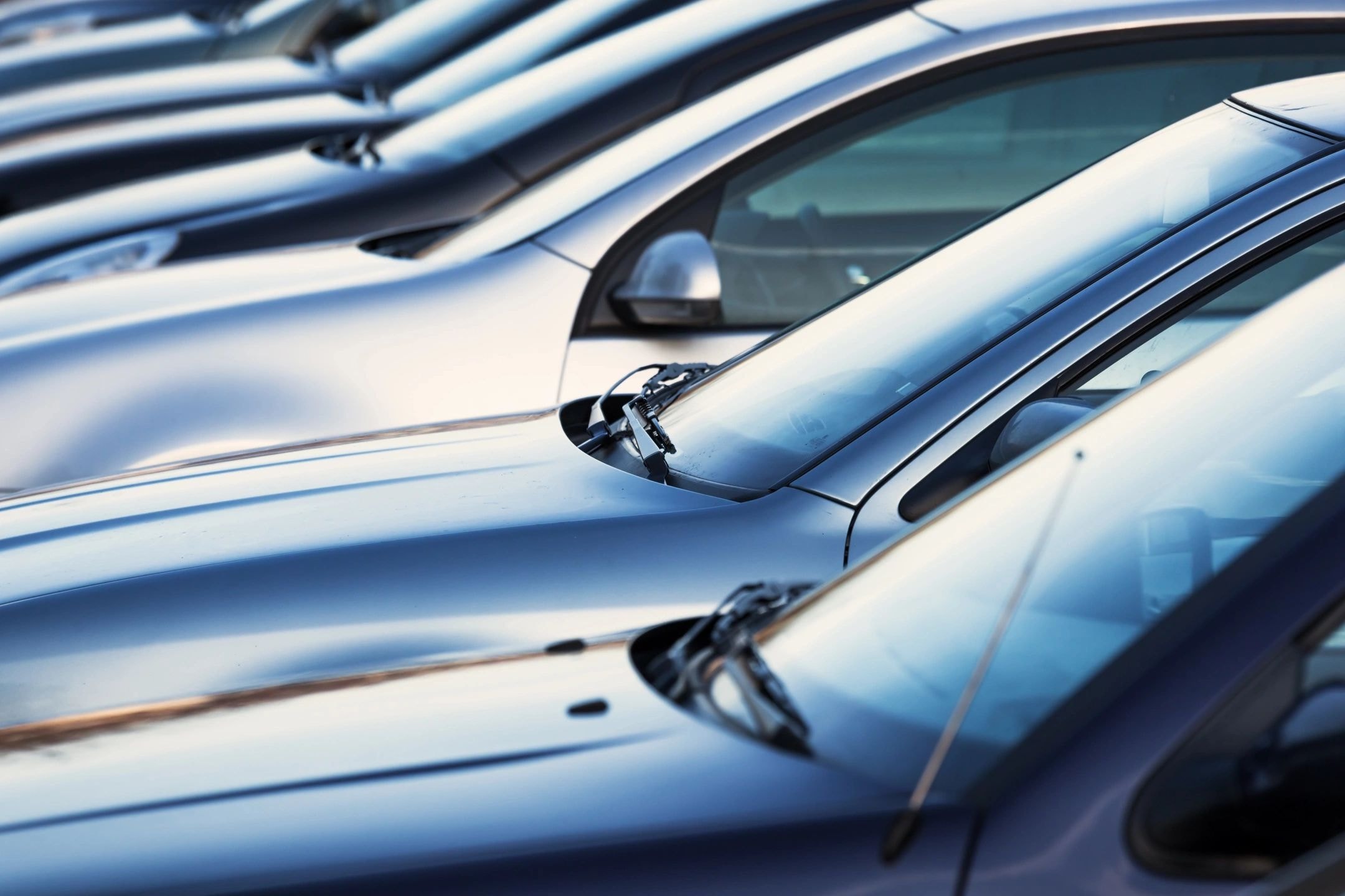 Close-up white silver cars parked row selective focus